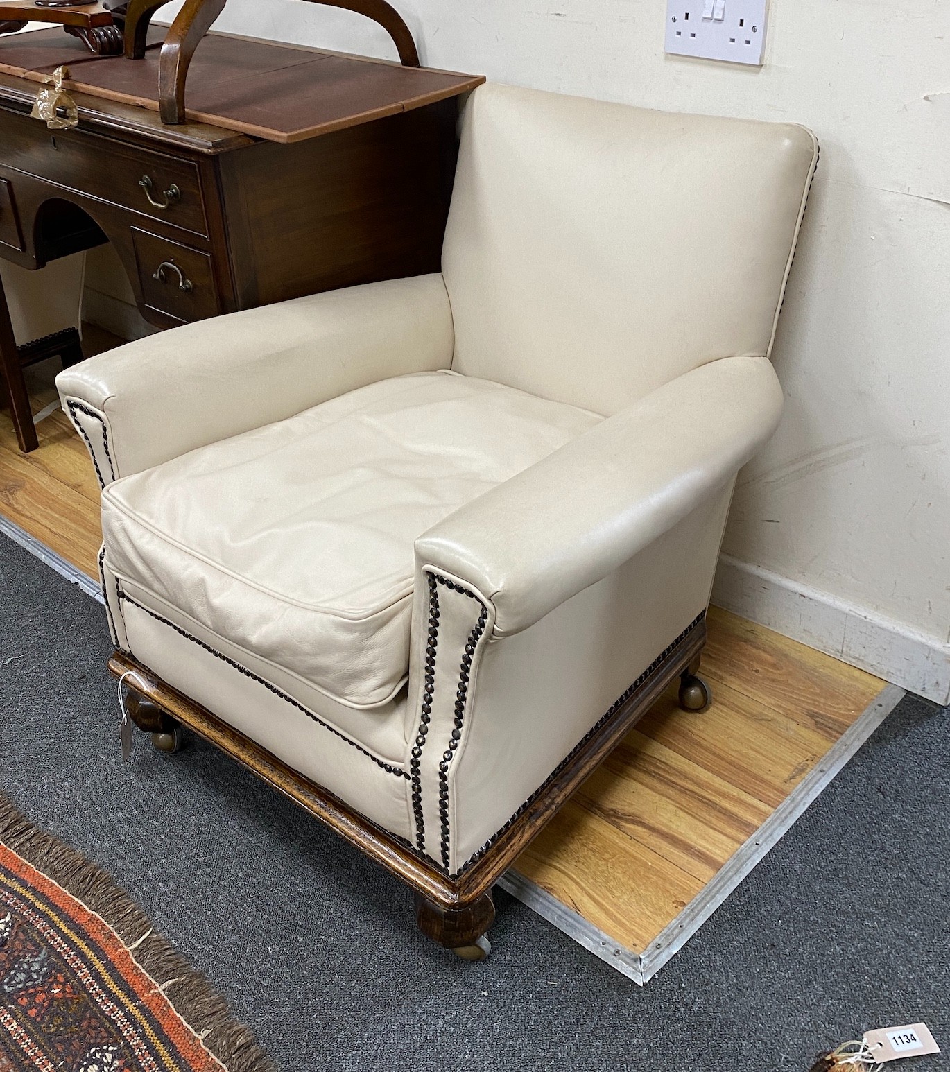 A pair of early 20th century oak cream leather club armchairs, width 76cm, depth 79cm, height 78cm